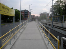 Looking up to the platform for trams to Manchester from by the pedestrian level crossing